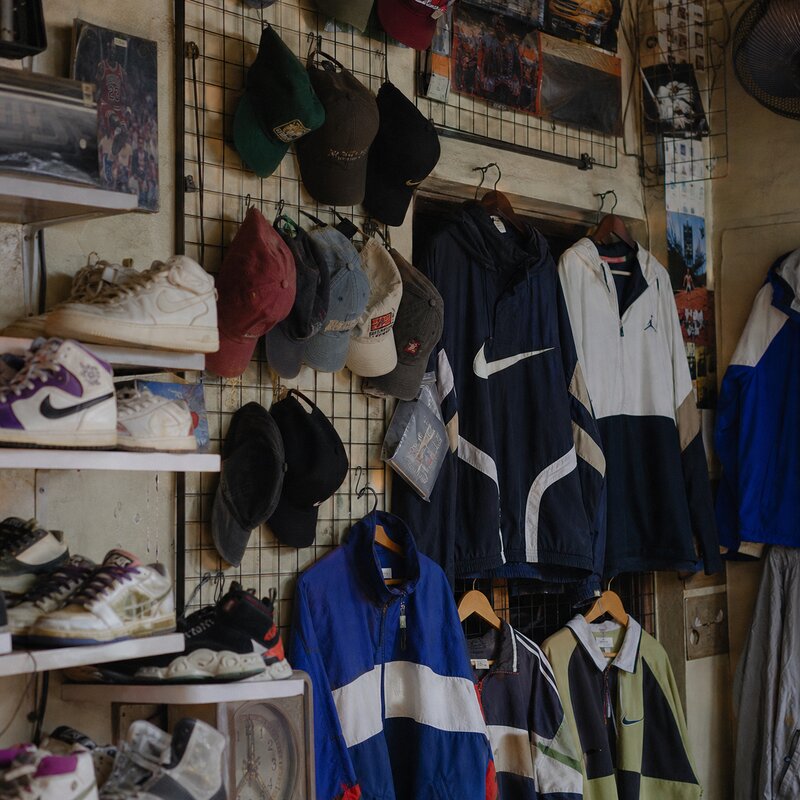 A display of hype vintage streetwear -- caps, sneakers, and branded jackets